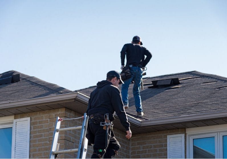 two men inspecting a roof for quality