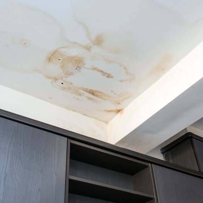 inspecting water damage on a ceiling